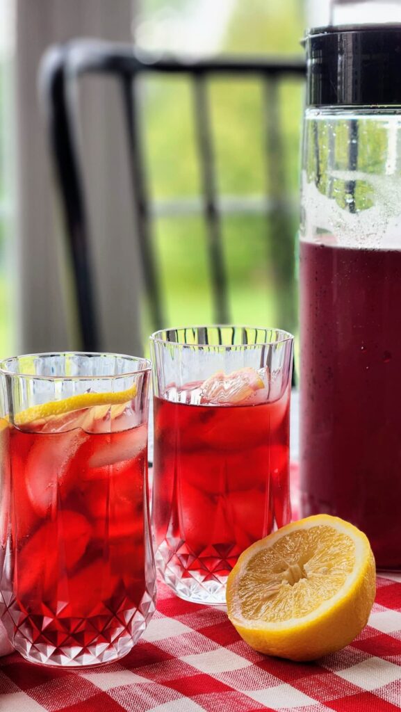 Crimson berry iced tea in two glasses with lemon slices