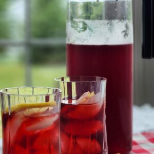 iced tea pitcher with crimson berry red tea in two glasses with lemon