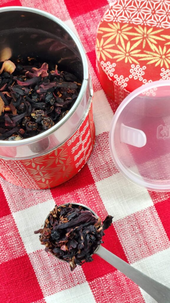 a perfect teaspoon of loose tea with tea tin filled with tea