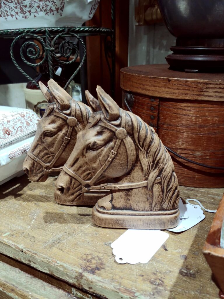 antique horse bookends on table in store