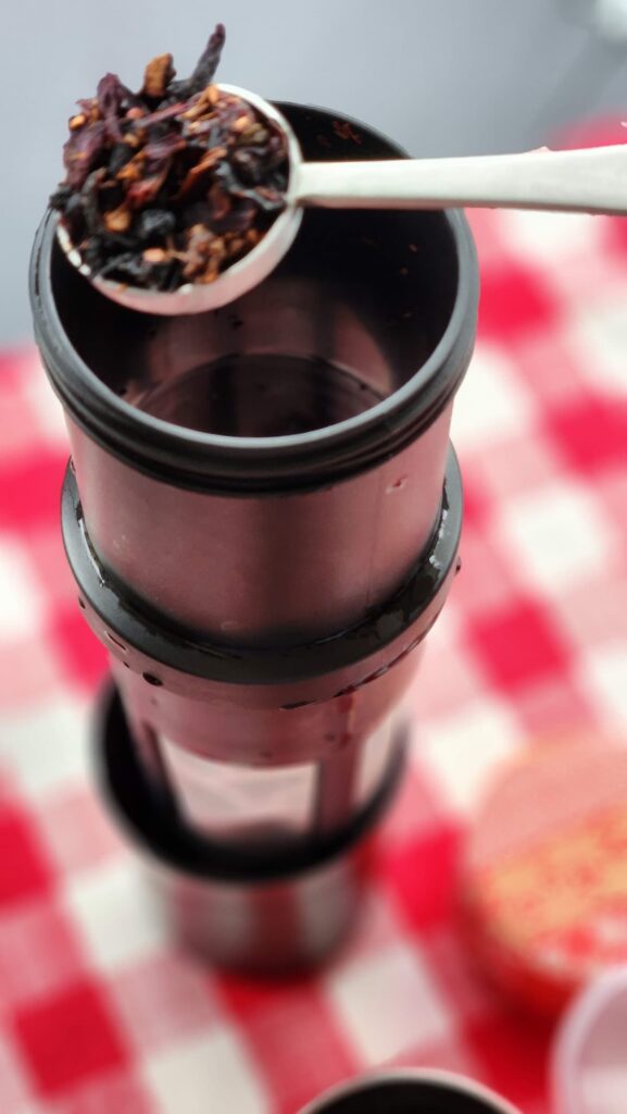 overhead view of large tea filter with scoop of tea being put in it