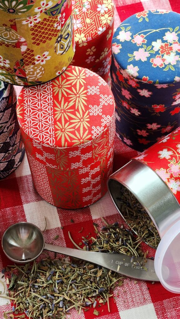 overhead view of tea tins with loose tea on table