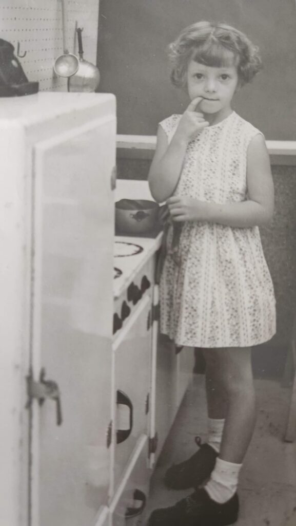 young girl in kindergarten at a play kitchen sink