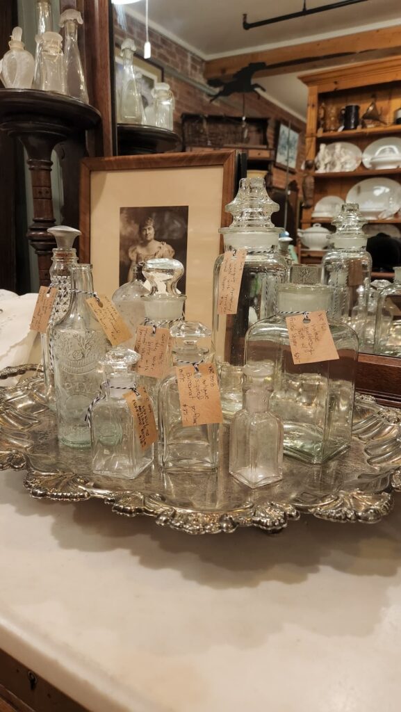 vintage perfume bottles on silver tray in antique shop