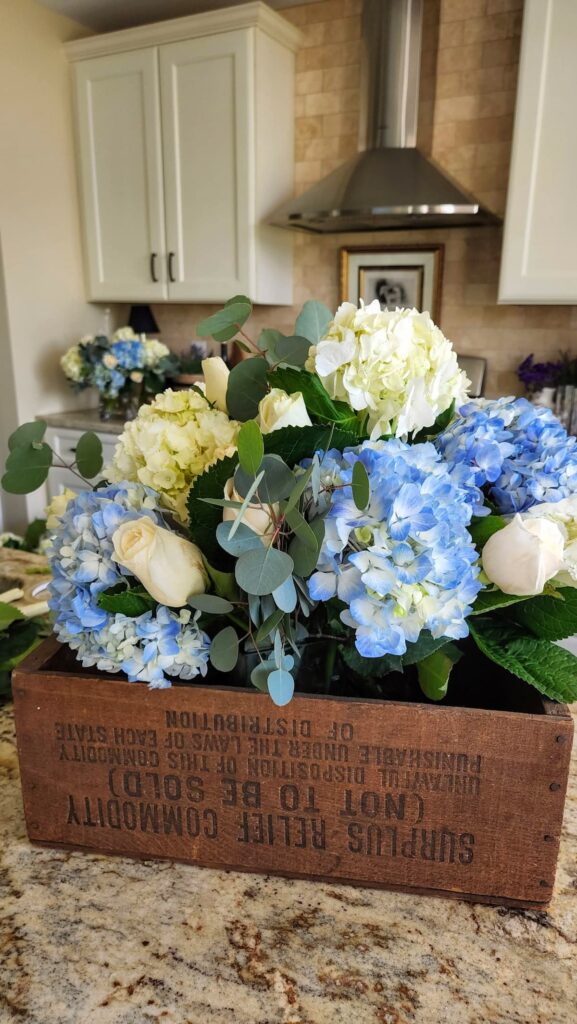 antique wooden box with blue and white hydrangea arrangement in it