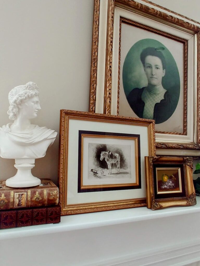 portrait of lady in antique frame hanging over fireplace mantel