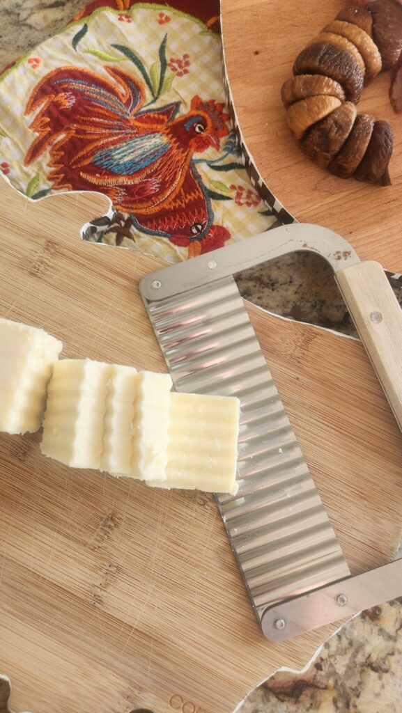 wooden cutting board with ripled sliced cheese