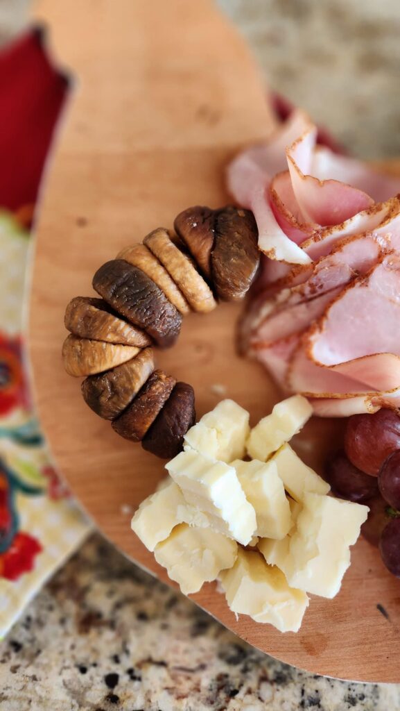 small charcuterie with figs cheese, sliced ham 