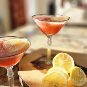 two martini style glasses with pink lemonade vodka freeze in them