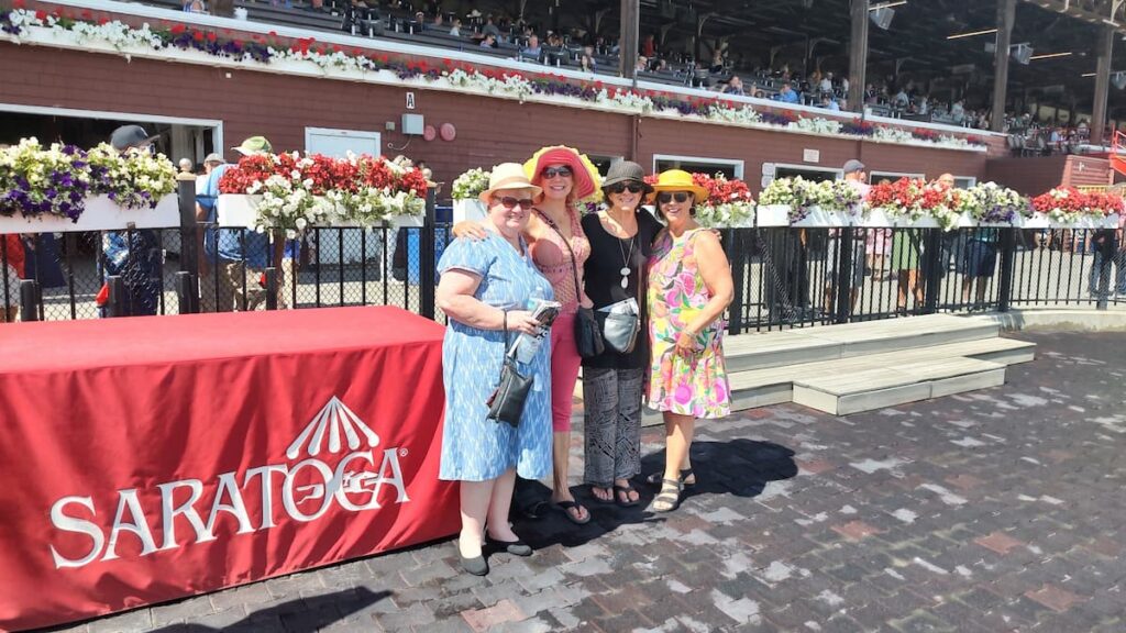 a group of ladies at saratgoa racetrack in the winners circle