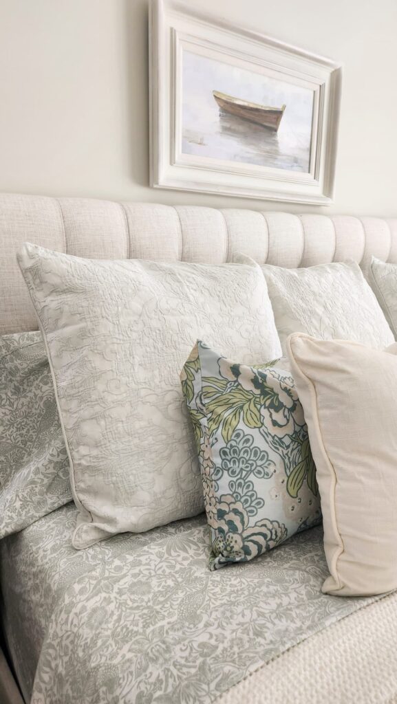 view of an upholstered headboard with pretty pillows
