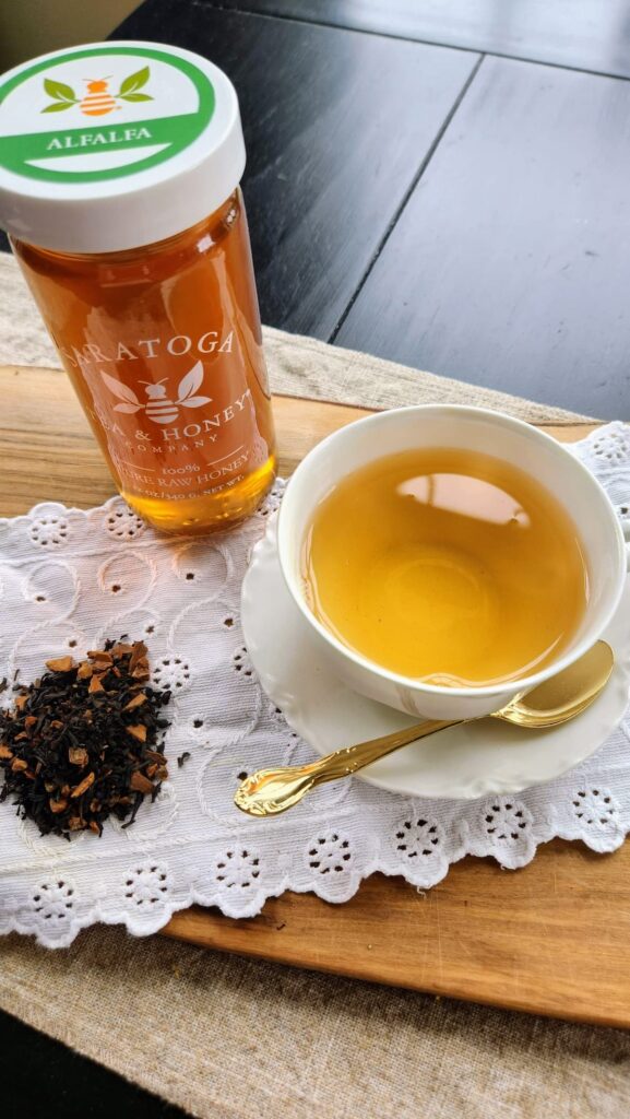 Istanbul apple loose tea in cup next to alfalfa honey jar