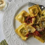 sauteed ravioli on dish with sundried tomatoes, artichoke hearts and capers