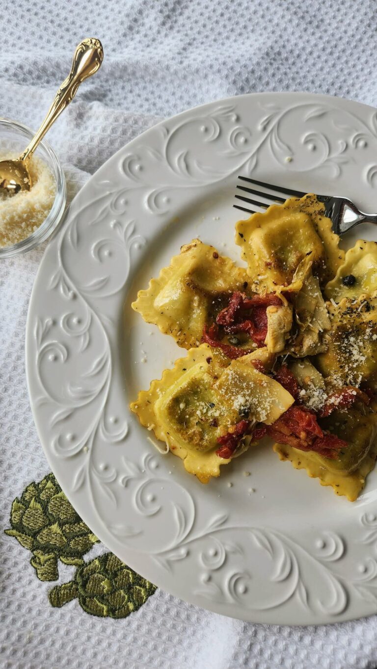 sauteed ravioli on plate with sundried tomatoes, artichokes and capers