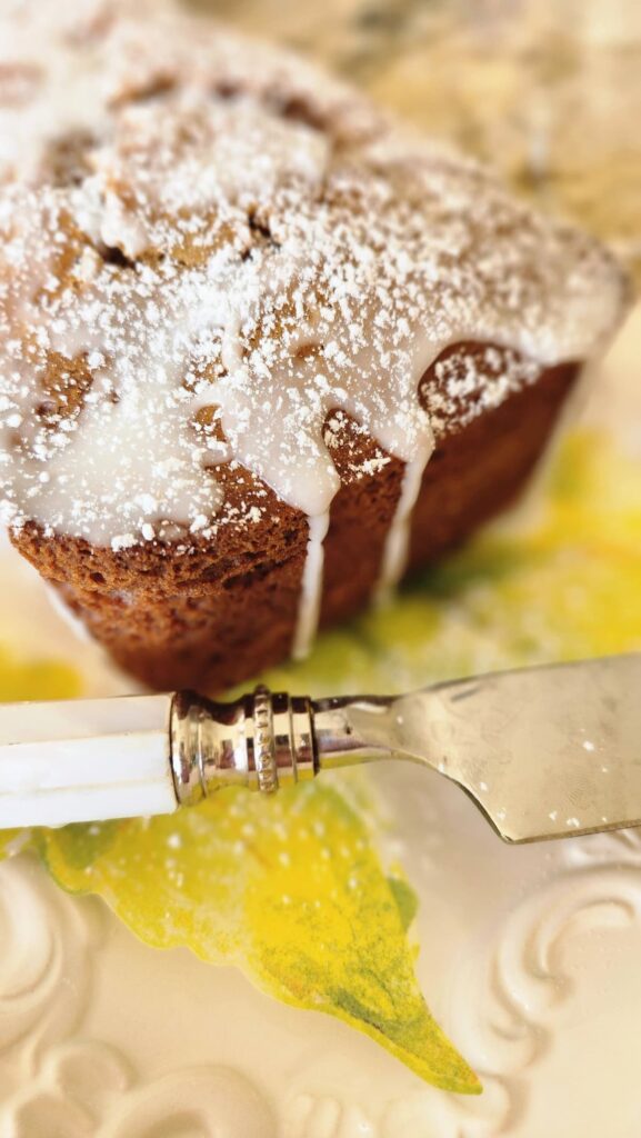 pumpkin bread with icing on top and sprinkled confectionery sugar