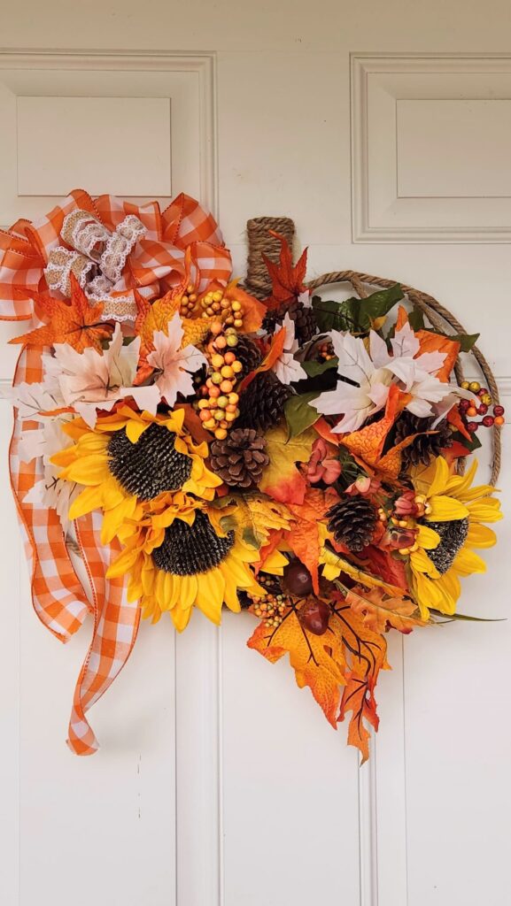 pumpkin wreath on front door with yellow sunflowers and orange bittersweet in it