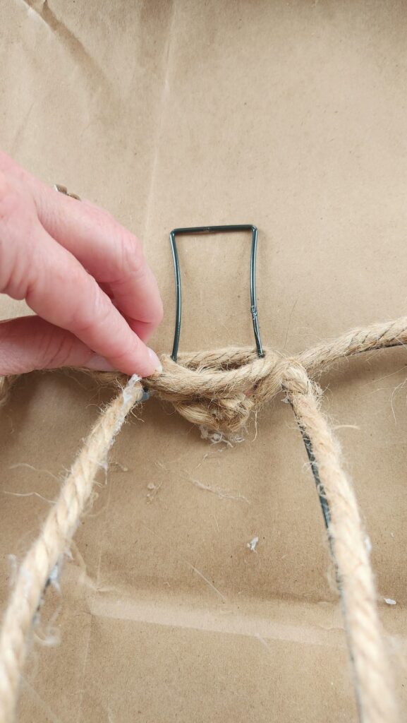 jute being glued to the stem of the pumpkin wire wreath