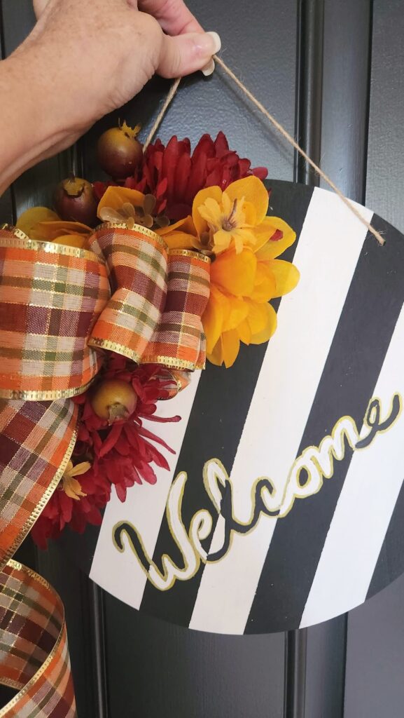 fall diy door hanger being held up by string to see what it will look like on the door