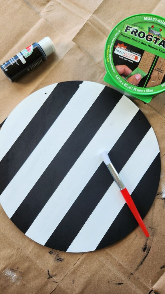 round wooden door hanger painted with black and white stripes