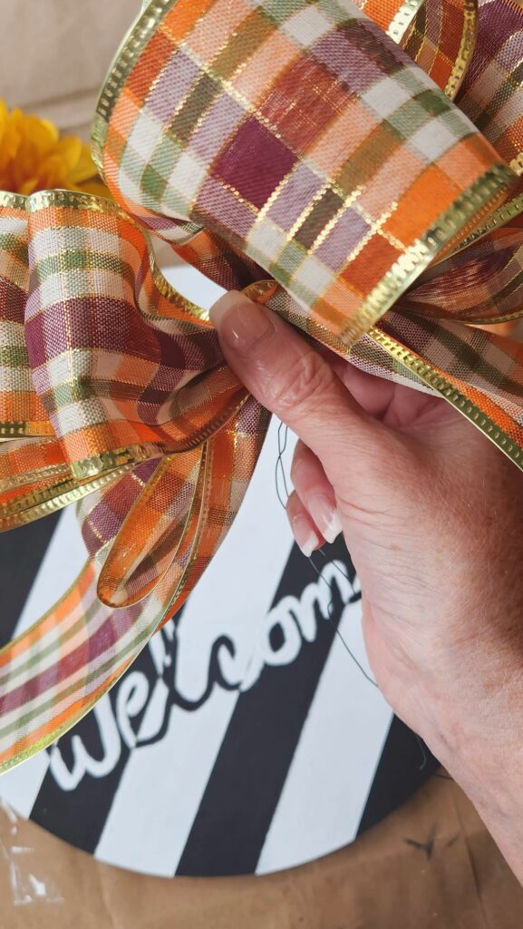 fall colored plaid ribbon being folded to make a large bow