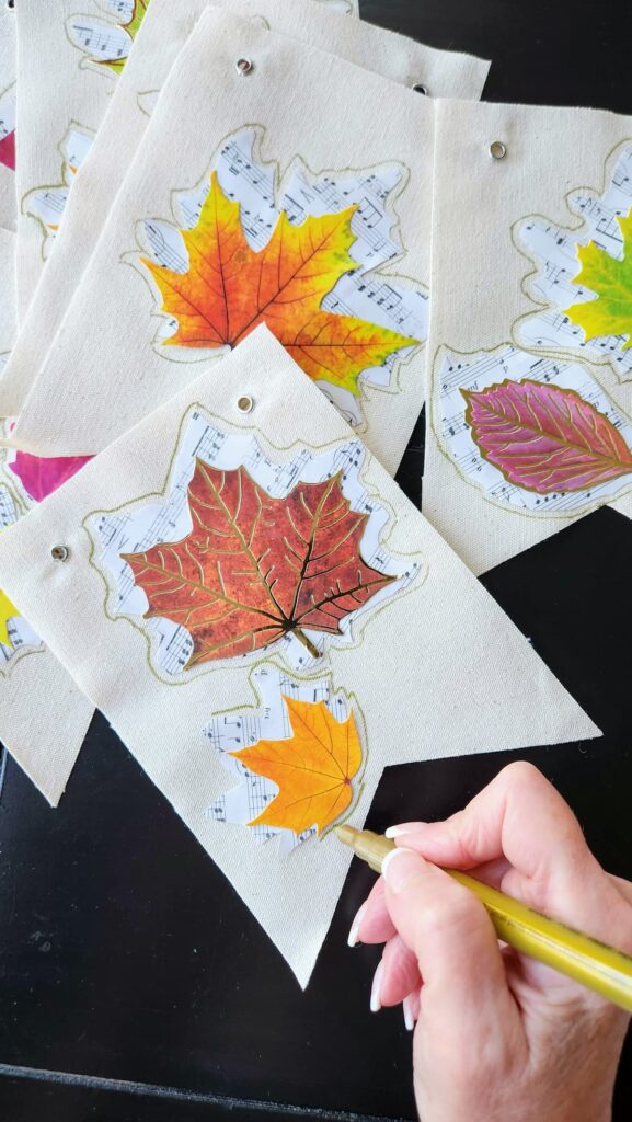 placing leaves on top of canvas banner with mod podge