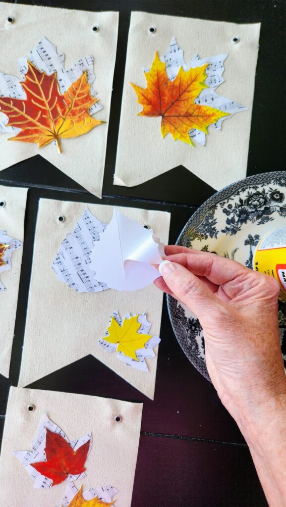 peeling the back of paper leaf to adhere to top of another paper leaf