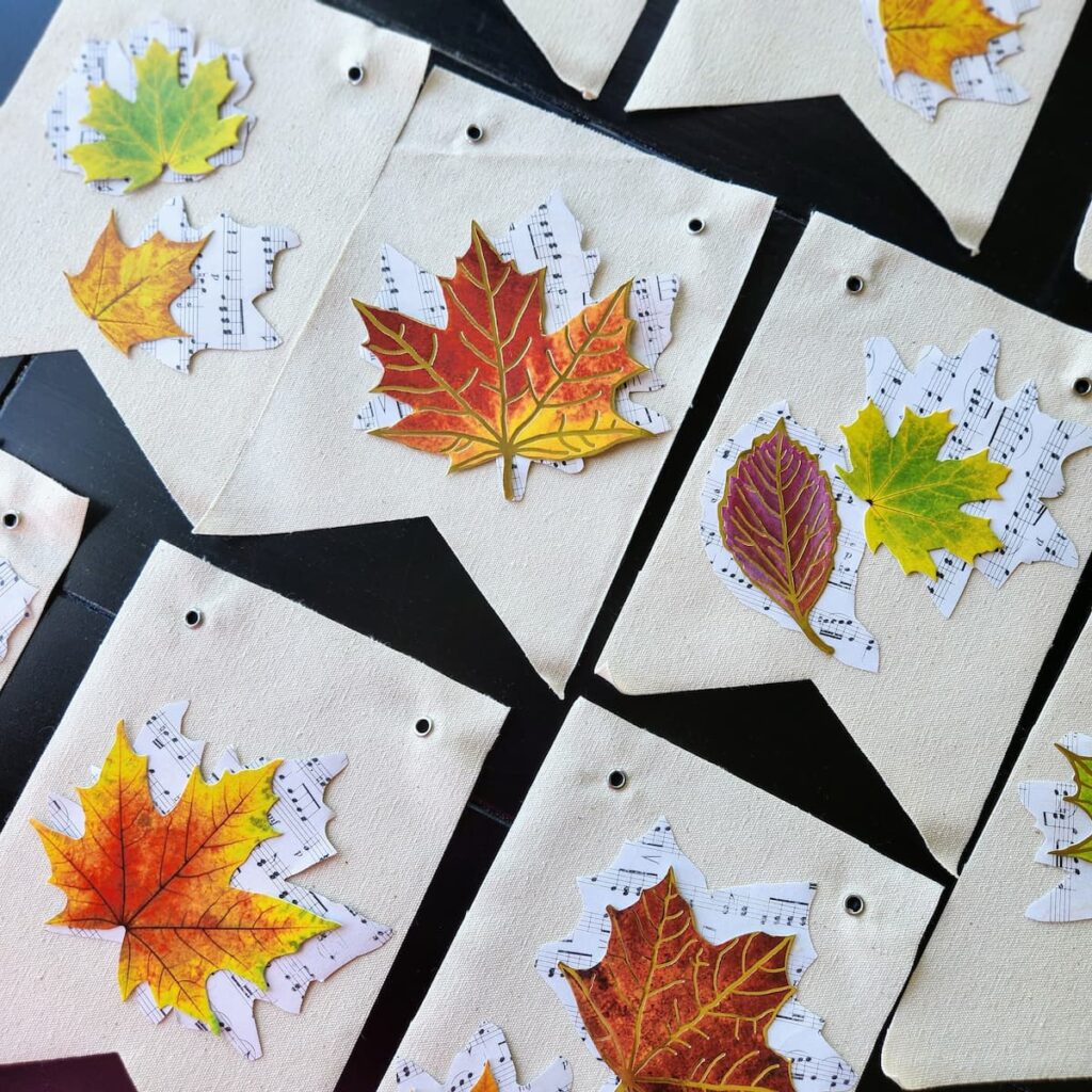 several banner pieces with leaves being placed on top of them to be glued