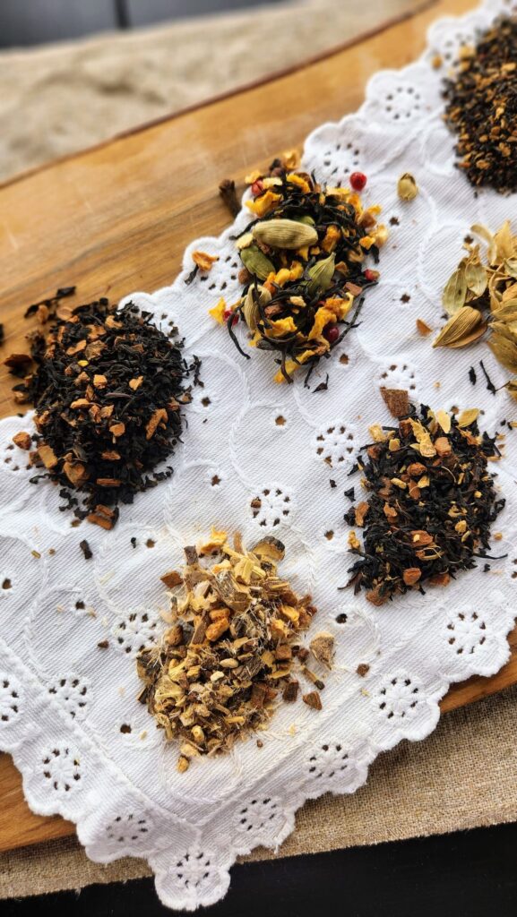 overhead photo of several looseleaf teas on white doily and wood cutting board