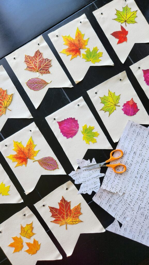 canvas banner pieces on table with leaves being placed on the top of them