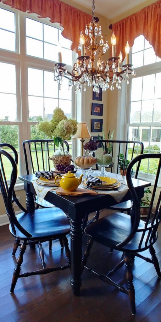 fall table with chandelier and wooden pumpkins on table