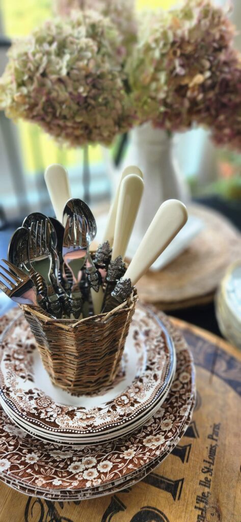 mini wicker basket filled with vintage ivory silverware pieces on a table