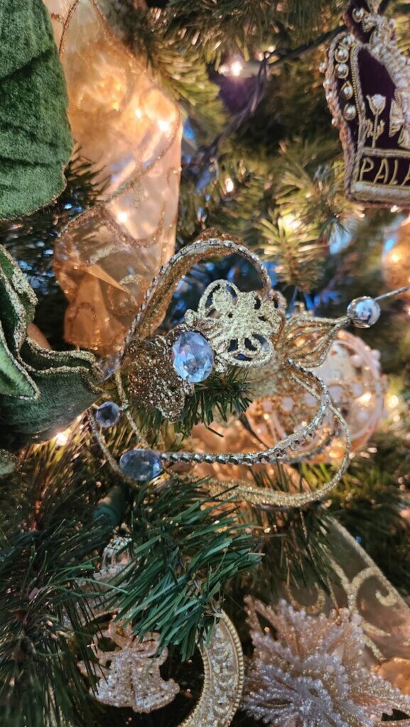 gold crown ornament with crystal embellishment hanging on christmas tree