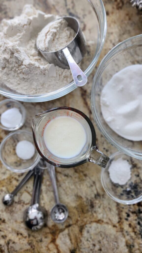 metal measure cup in glass bowl of flour for scone recipe