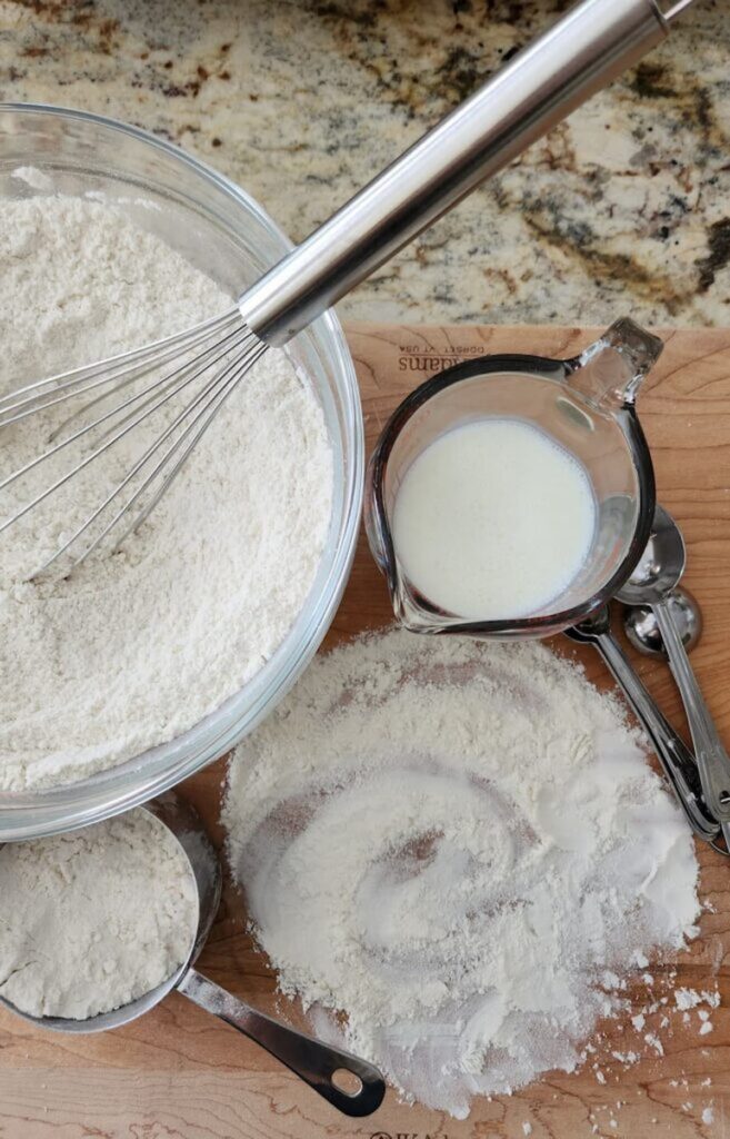 overhead of flour in glass bowl with buttermilk ready to be added