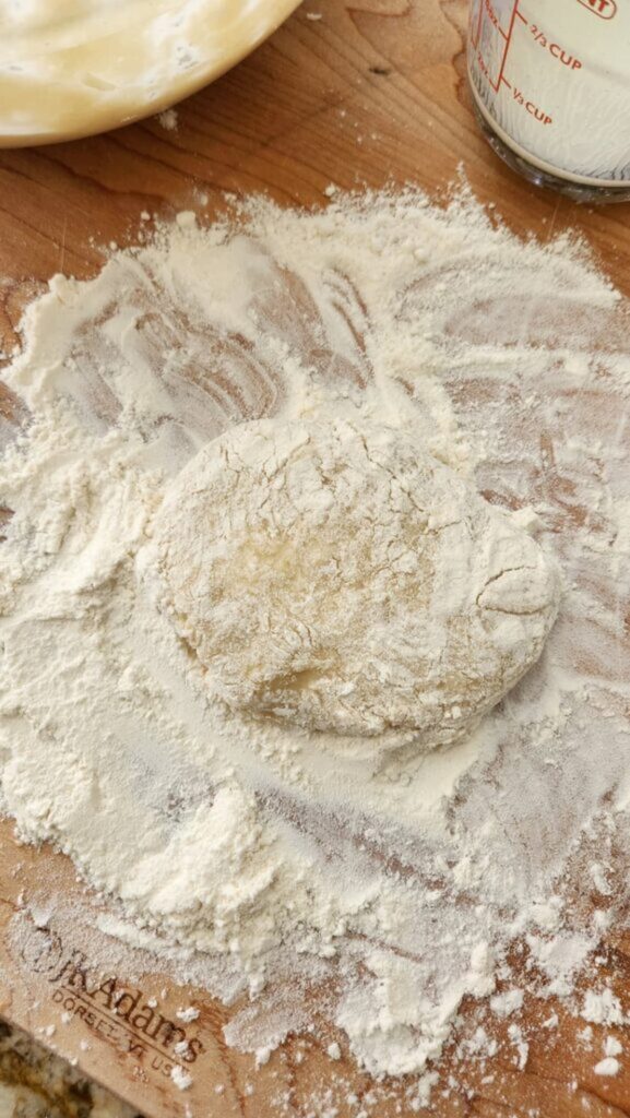 floured cutting board with round dough ready to be cut into small scones
