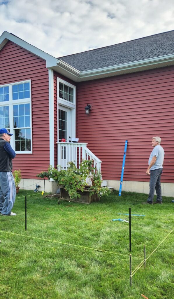 back yard with the beginning measuring of a screened porch being done