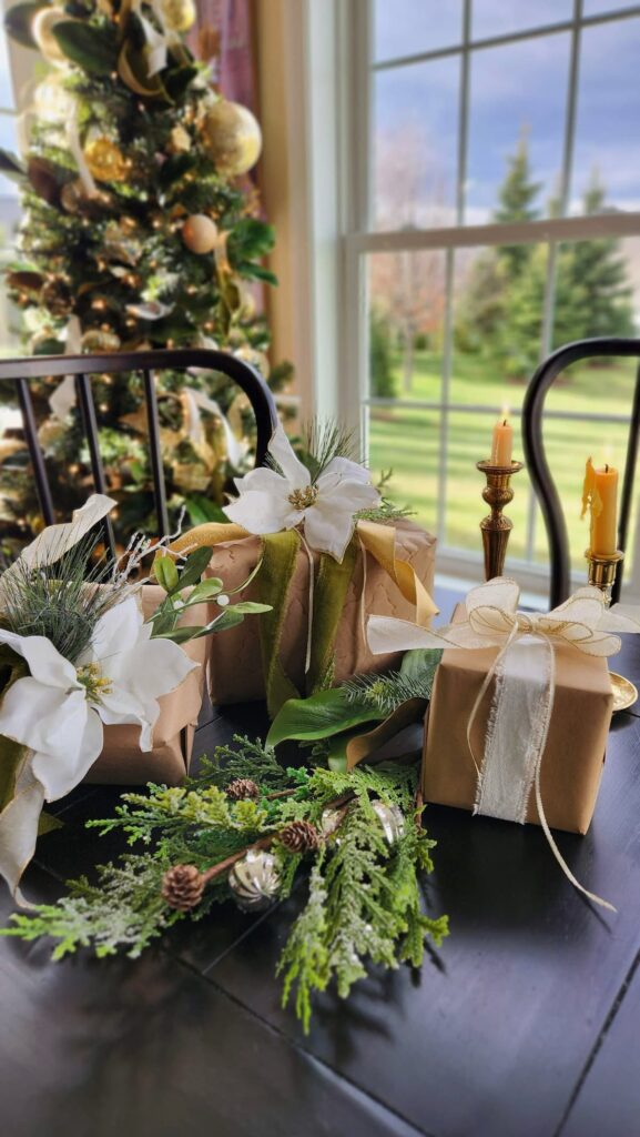 christmas presents wrapped in brown paper and string on table with christmas tree in background