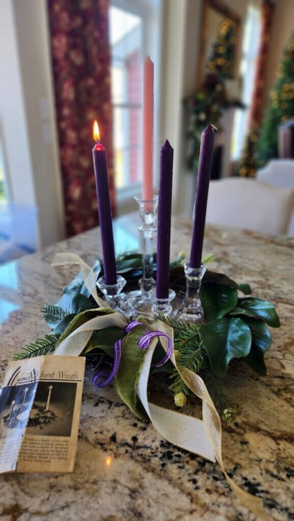 finished diy advent wreath with candles lit on the kitchen counter