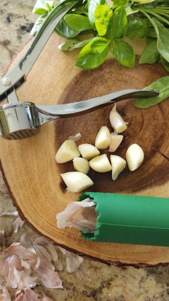 fresh herbs with garlic and garlic roller on counter