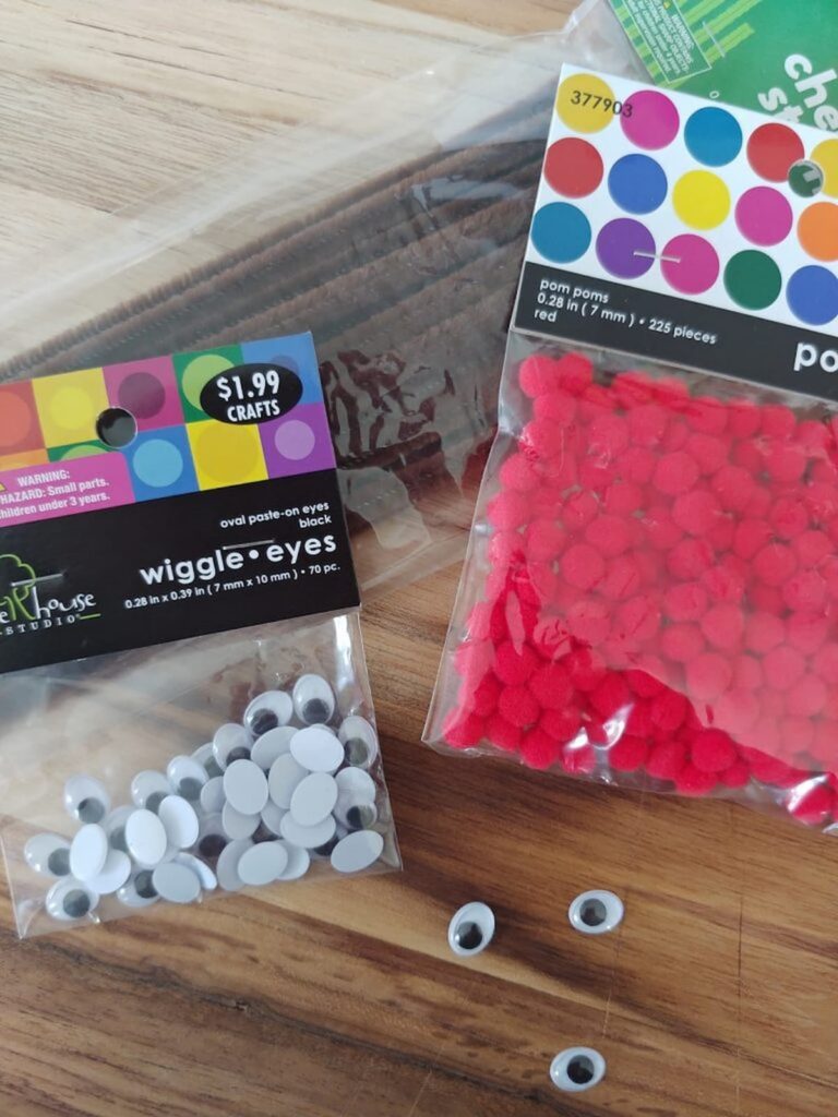 bag of red pom poms and google eyes for reindeer bottle diy craft