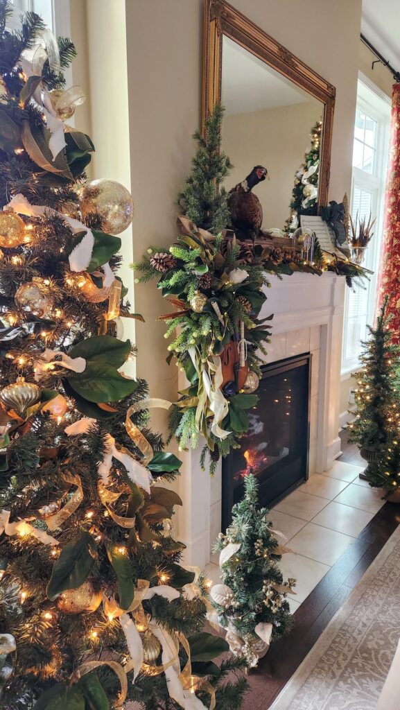 view of mantel with three christmas trees on the side of it all decorated in gold and ivory