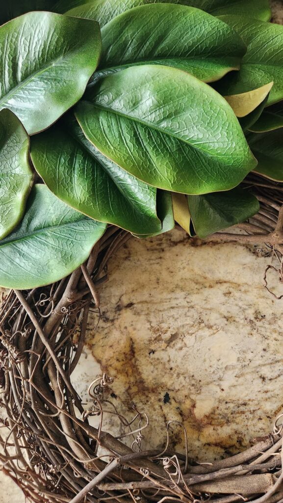 grapevine wreath with magnolia leaves being added