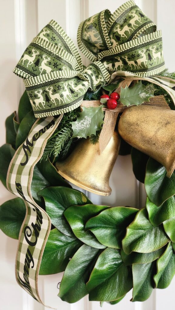 faux magnolia wreath hanging on white door