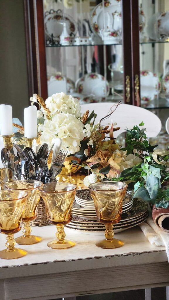 Amber stemware on table with dishes and centerpiece in background