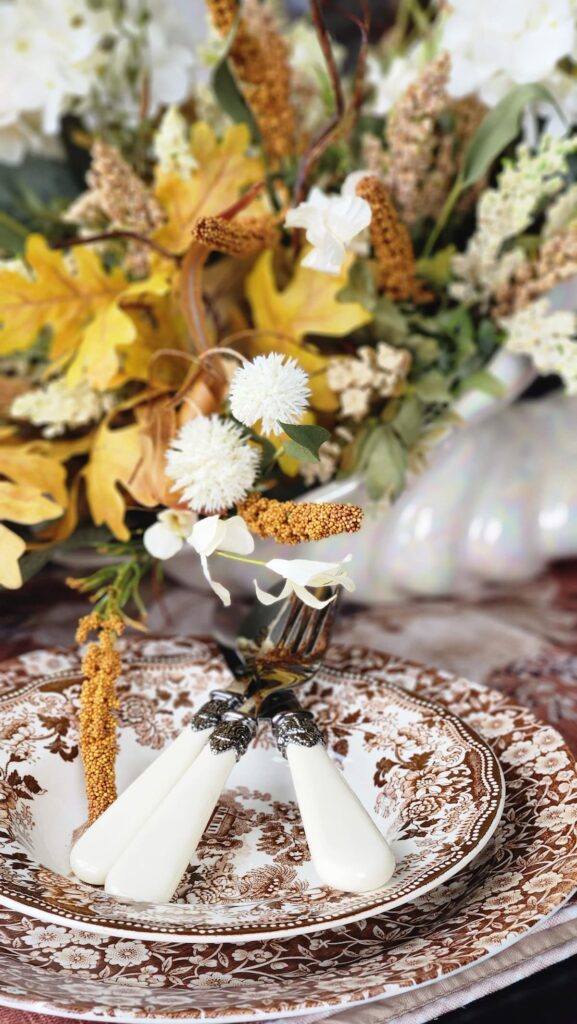 brown chintz vintage dishes with vintage silverware on top of dishes