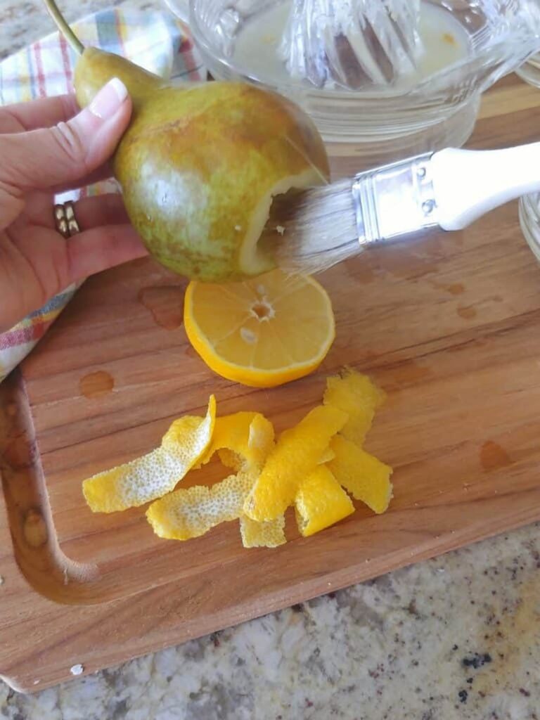pastry brush brushing inside of cored pear
