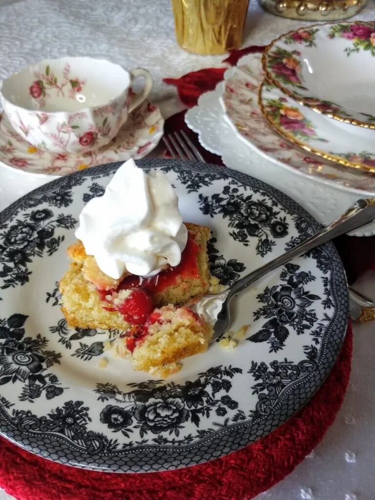 cherry tart on dish with whipped topping on top