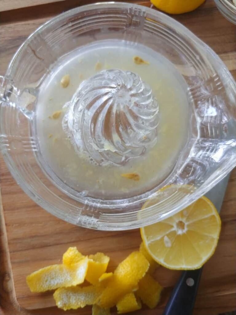 glass lemon sqeeze bowl with lemon juice in it 