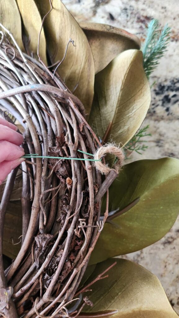 green ornament hook on back of wreath to attach the two gold bells to the front of the wreath