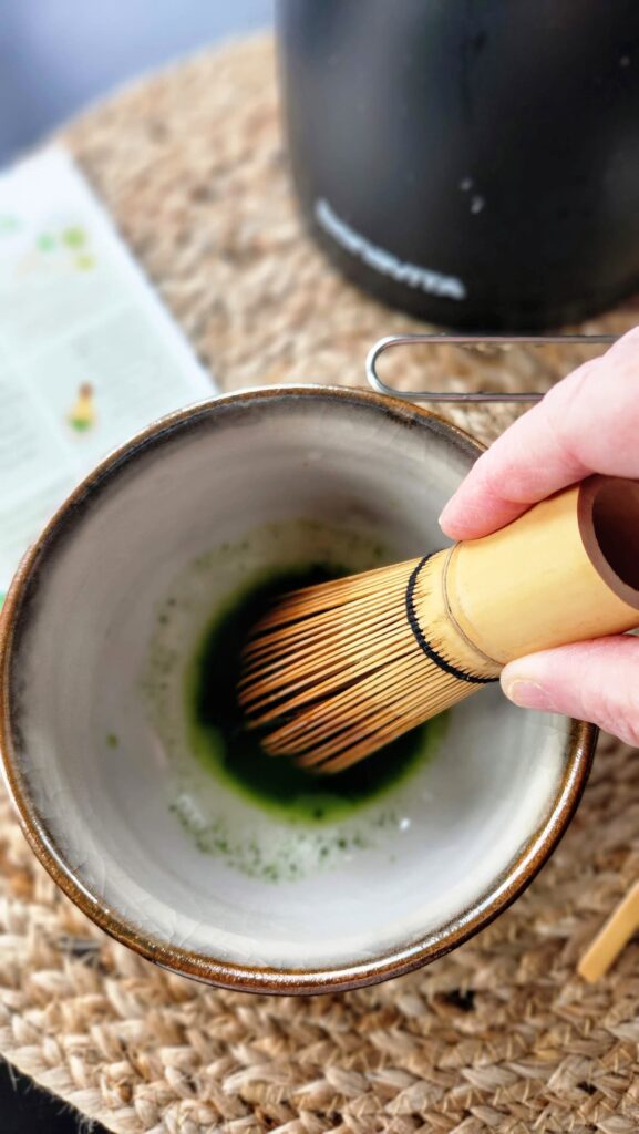 slowly adding the water to the matcha and matcha bowl to whisk the matcha